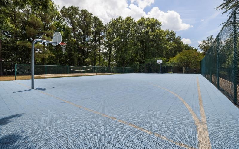 a basketball court with trees on the side