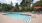 a swimming pool with chairs and umbrellas