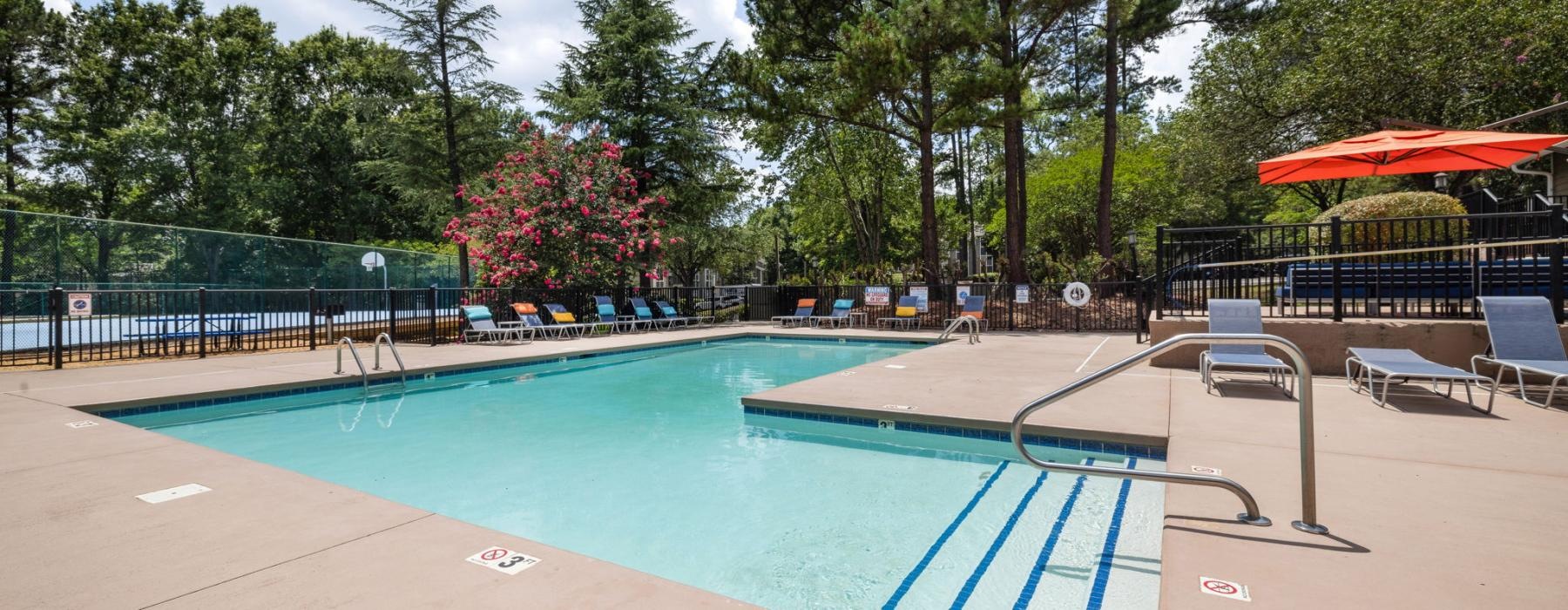 a swimming pool with chairs and umbrellas