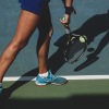 close up of a person holding a tennis racquet 
