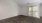 a room with a wood floor and a window with blinds